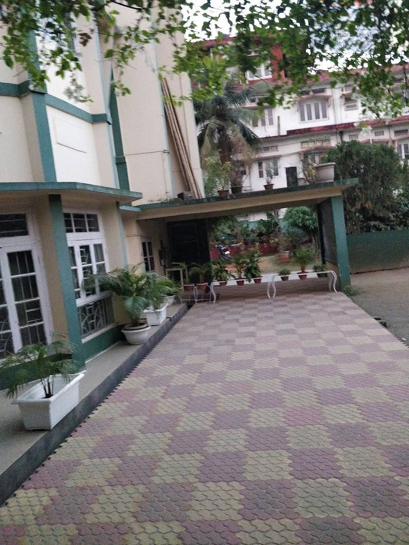 The Good Shepherd school building in Guwahati with a checkered paved courtyard and potted plants